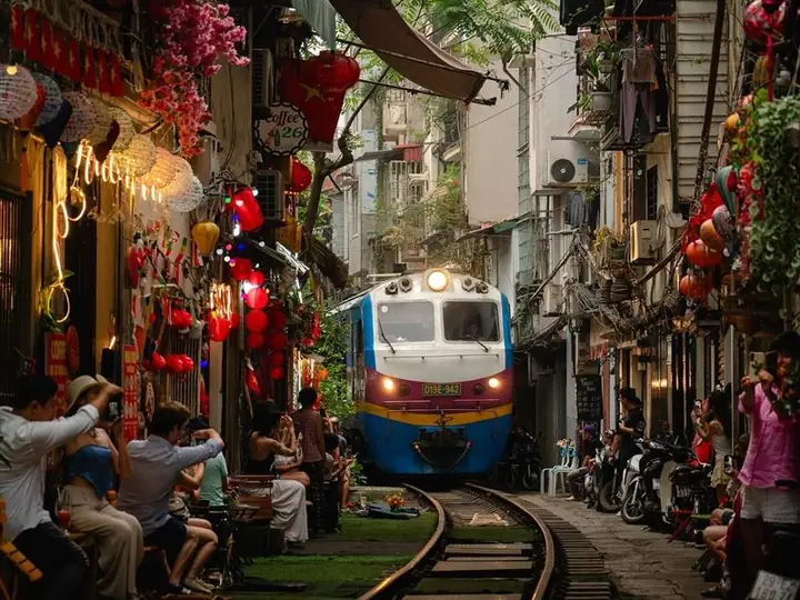 Поезд проходит между кафе на Train Street в Ханое